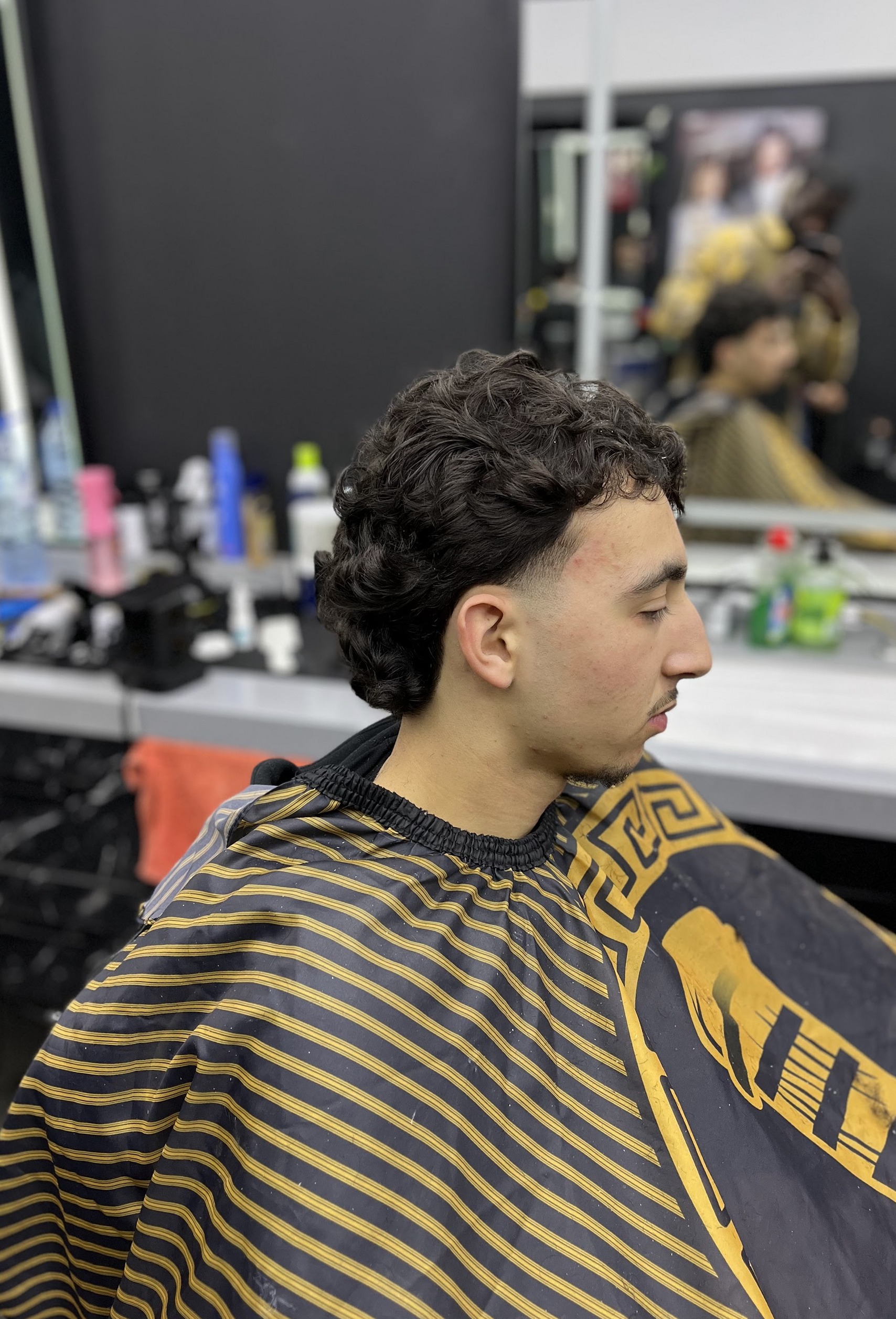 Afgewerkt kapsel met krullen en een geleidelijke overgang bij SIGNATURE_CUTZ